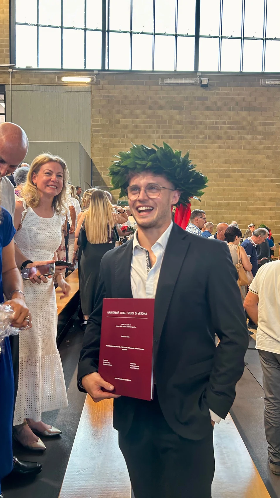 Fotografia di un momento di laurea con tesi e corona d’alloro