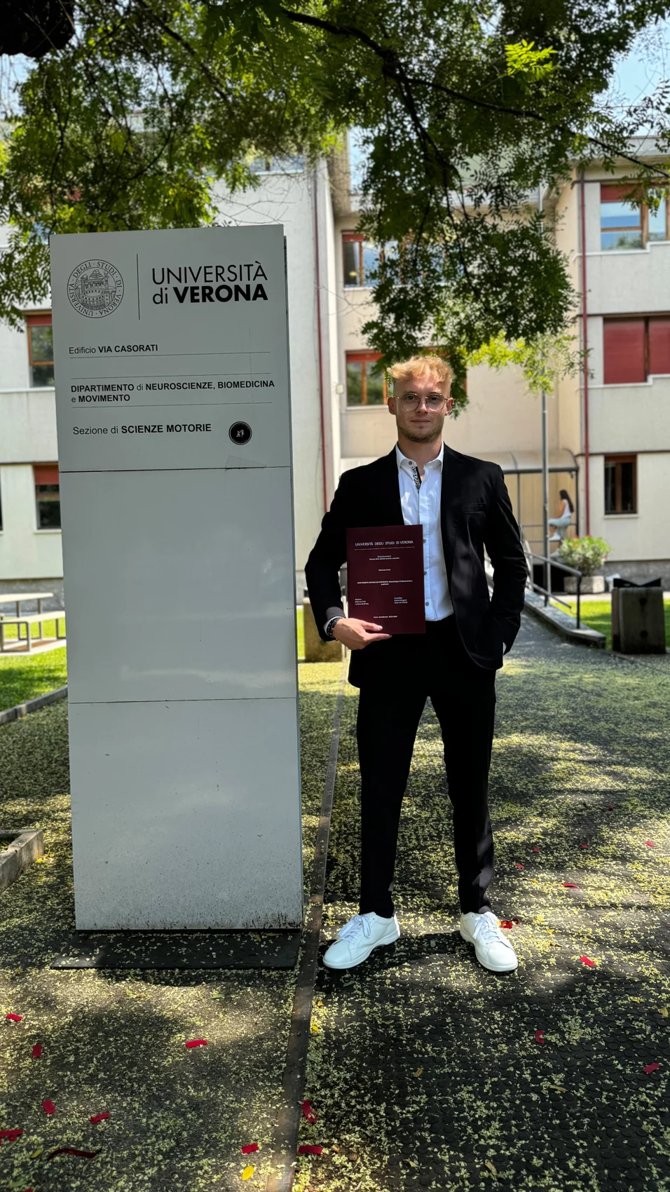 Fotografia accademica accanto all’insegna dell’Università degli Studi di Verona